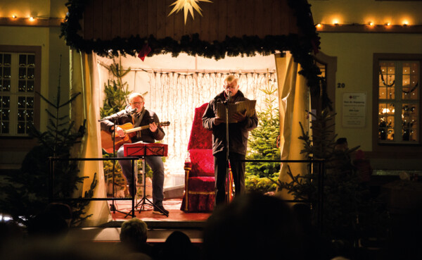 Twee mannen op een podium in kerstsfeer met een gitaar en een liedboek © Henry Tornow